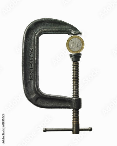 Photo: A coin in a clamp. Feeling the pinch, economic squeeze. A coin in a clamp. Feeling the pinch, economic squeeze.