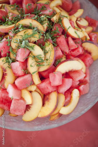 Photo: Organic prepared farm stand party food. Summer fruit salad of watermelon, peaches and mint. Organic prepared farm stand party food. Summer fruit salad of watermelon, peaches and mint.