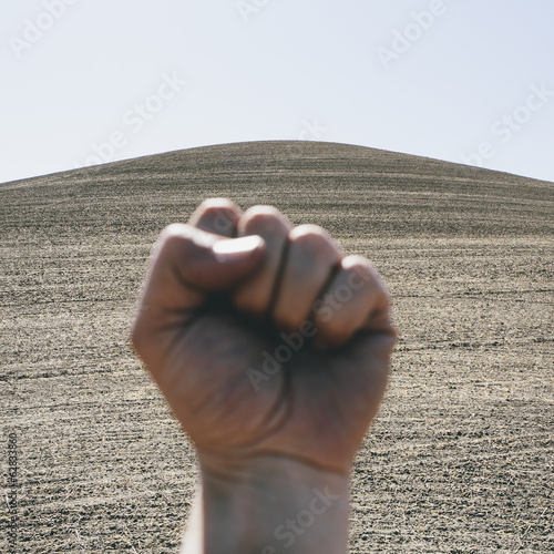 Photo: A hand bunched up and making fist, making a gesture. A ploughed field and farmland in the background, near Pullman in Washington state. A hand bunched up and making fist, making a gesture. A ploughed field and farmland in the background, near Pullman in Washington state.