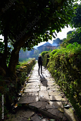 Photo: Trekker with backpack in a mountain village Trekker with backpack in a mountain village