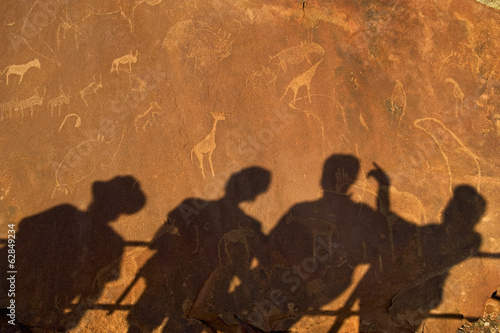 Photo: The shadows of tourists at a viewing point, on the surface of the rock at Twyfelfontein World Heritage Site at Uibasen Conservancy, Damaraland, Namibia. The shadows of tourists at a viewing point, on the surface of the rock at Twyfelfontein World Heritage Site at Uibasen Conservancy, Damaraland, Namibia.