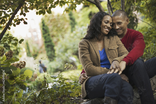 Foto: Scenes from urban life in New York City. A man and a woman, a couple sitting close together under the trees. Scenes from urban life in New York City. A man and a woman, a couple sitting close together under the trees.