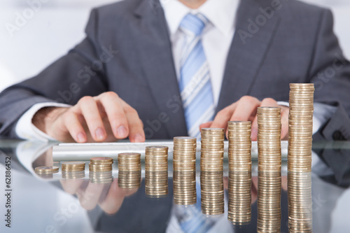 Photo: Businessman With Keyboard And Coin Stack Businessman With Keyboard And Coin Stack