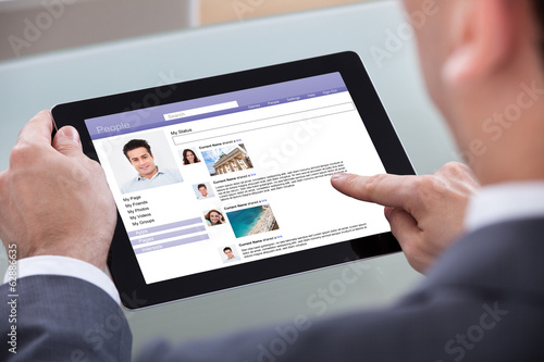 Photo: Close-up Of Man Browsing On Digital Tablet Close-up Of Man Browsing On Digital Tablet