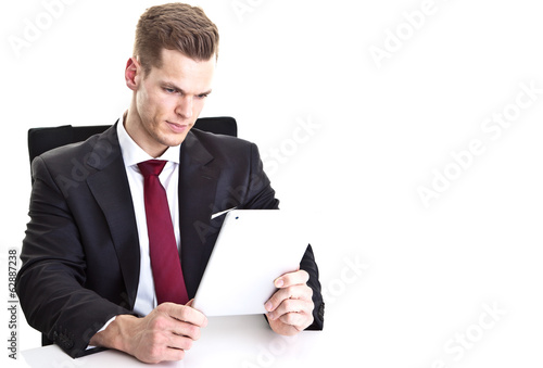 Photo: Hübscher Mann im Anzug liest auf Touchscreen Hübscher Mann im Anzug liest auf Touchscreen