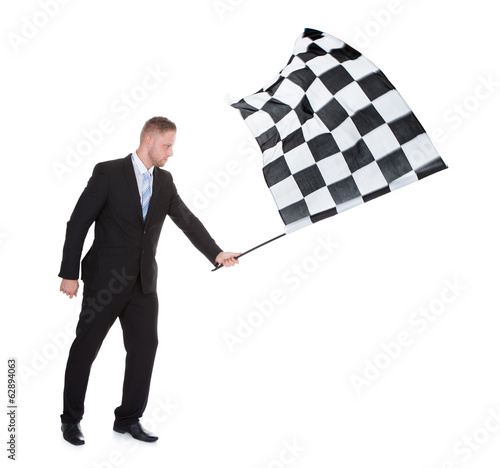 Photo: Conceptual image of a stylish young businessman waving a flag Conceptual image of a stylish young businessman waving a flag