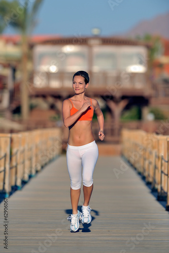 Photo: young woman jogging on the beach young woman jogging on the beach