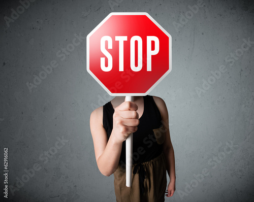 Photo: Young woman holding a stop sign Young woman holding a stop sign