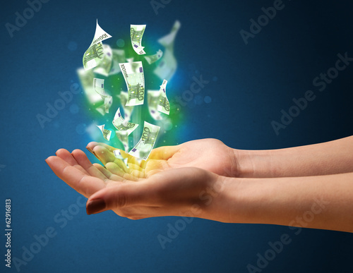 Photo: Glowing money in the hand of a woman Glowing money in the hand of a woman