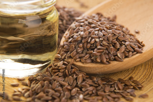 Photo: Linseed oil and flax seeds on wooden background Linseed oil and flax seeds on wooden background