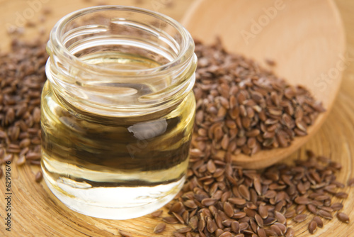 Photo: Linseed oil and flax seeds on wooden background Linseed oil and flax seeds on wooden background