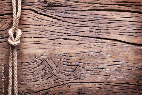 Photo: Sailor's knot over old wooden background. Sailor's knot over old wooden background.