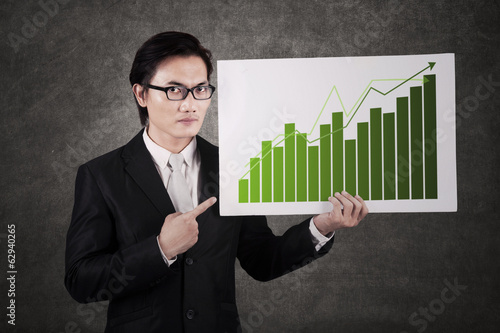 Photo: Businessman with chart of profits Businessman with chart of profits