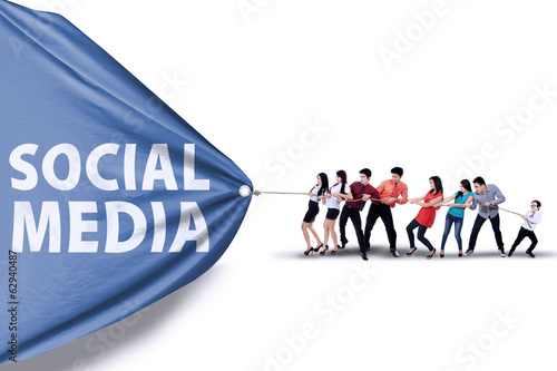 Photo: Businessteam pulling a banner of social media Businessteam pulling a banner of social media