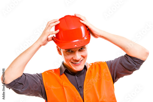 Photo: Man worker in safety vest and hard hat. Safety in work. Man worker in safety vest and hard hat. Safety in work.