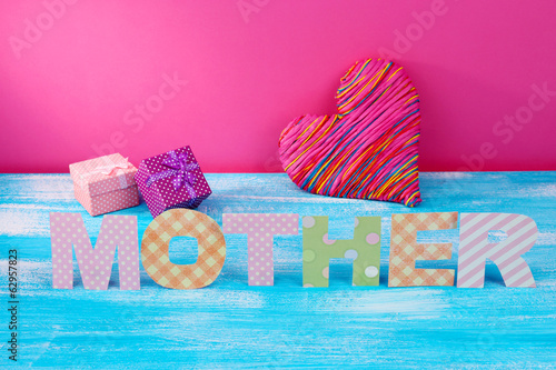 Photo: Mother- lettering of handmade paper letters on pink background Mother- lettering of handmade paper letters on pink background