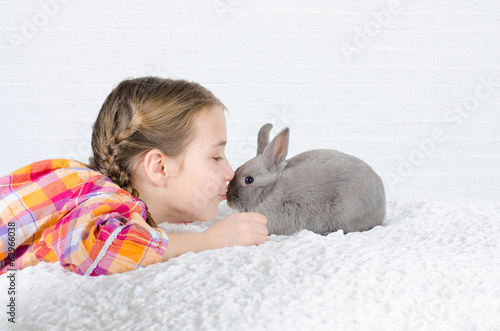 Photo: Mädchen gibt einem Hasen einen Kuss Mädchen gibt einem Hasen einen Kuss