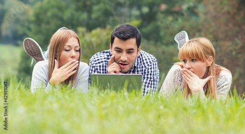 Photo: Worried friends study homework on laptop Worried friends study homework on laptop