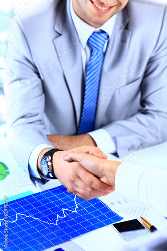 Photo: businessman shaking hands to seal a deal with his partner businessman shaking hands to seal a deal with his partner