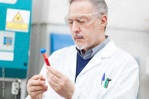 Photo: Scientists examining a test tube Scientists examining a test tube