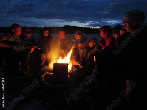 Photo: Tourists are heated at a fire at night Tourists are heated at a fire at night