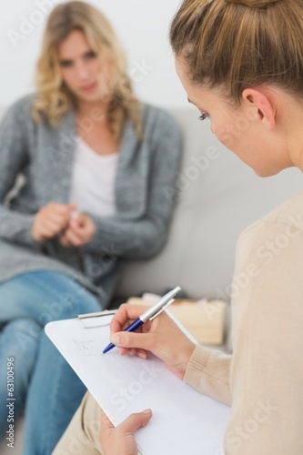 Photo: Therapist writing notes on her clipboard Therapist writing notes on her clipboard