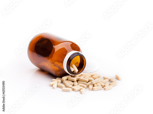 Photo: Medicine bottle and pills isolated on white background Medicine bottle and pills isolated on white background