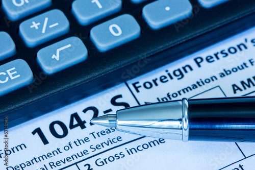 Photo: US tax form with pen and calculator US tax form with pen and calculator