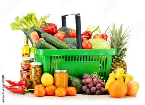 Photo: Plastic shopping basket with groceries isolated on white Plastic shopping basket with groceries isolated on white