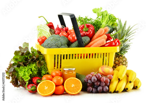 Photo: Plastic shopping basket with groceries isolated on white Plastic shopping basket with groceries isolated on white