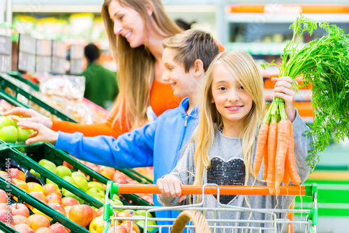 Photo: Famile beim Einkaufen im Lebensmittelmarkt Famile beim Einkaufen im Lebensmittelmarkt