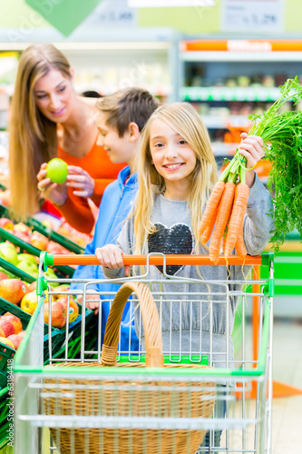 Photo: Famile beim Einkaufen im Lebensmittelmarkt Famile beim Einkaufen im Lebensmittelmarkt