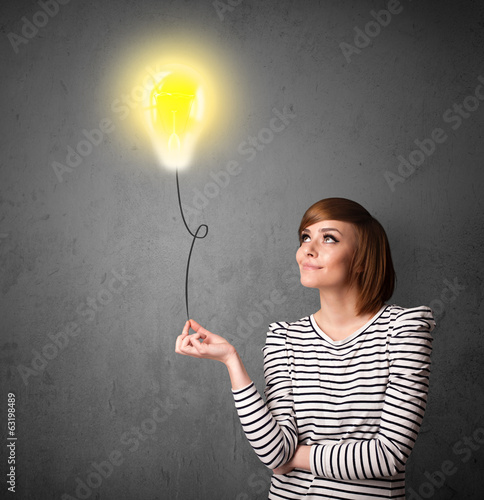 Photo: Woman holding a lightbulb balloon Woman holding a lightbulb balloon
