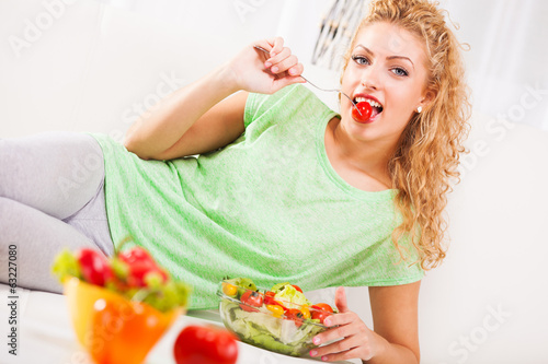 Photo: Young woman eating tomato Young woman eating tomato