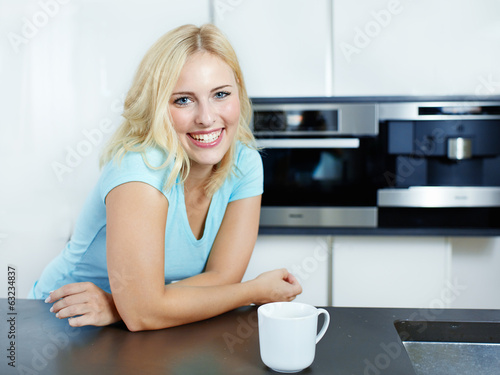 Photo: Happy woman in her kitchen Happy woman in her kitchen