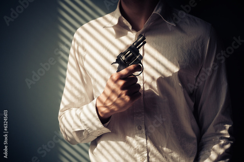 Photo: Man with gun by window Man with gun by window