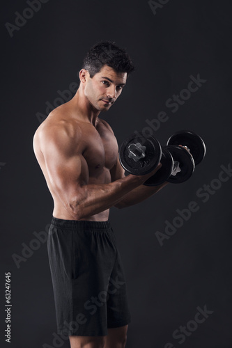 Photo: Muscular man lifting weights Muscular man lifting weights