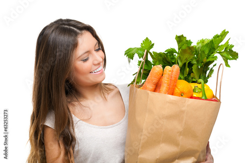 Photo: Young woman holding a shopping bag full of vegetables Young woman holding a shopping bag full of vegetables