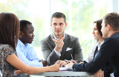 Photo: business partners discussing documents and ideas at meeting business partners discussing documents and ideas at meeting