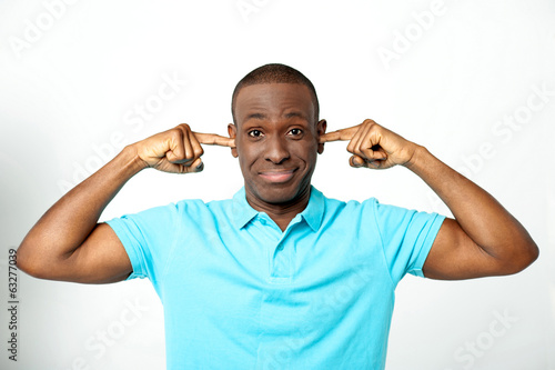 Photo: Young man covering his ears Young man covering his ears