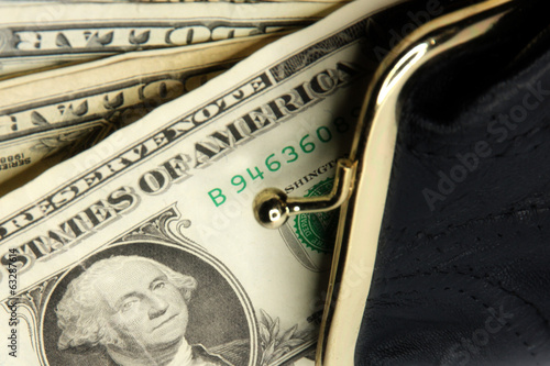 Photo: shallow paper dollars are in a black purse shallow paper dollars are in a black purse