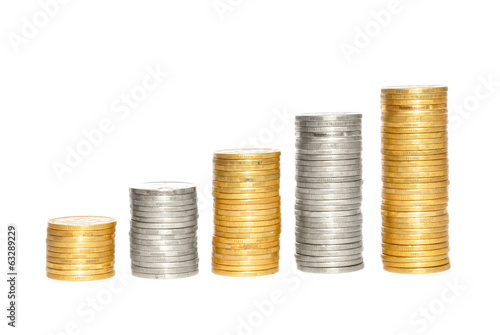 Photo: Savings, increasing columns of gold and silvercoins over white b Savings, increasing columns of gold and silvercoins over white b