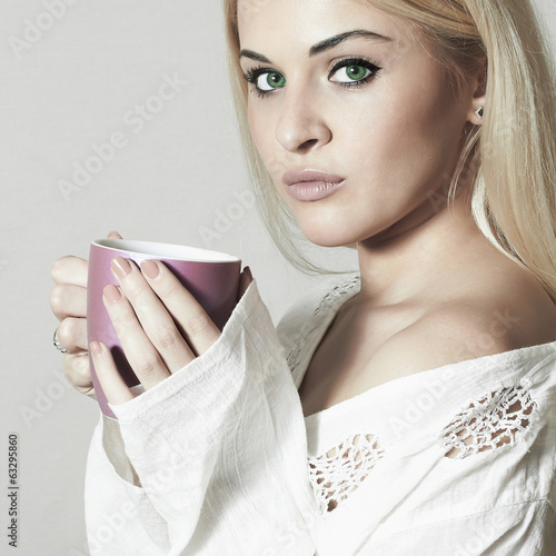 Photo: Beautiful Young woman drinking Coffee. Cup of tea. Hot drink Beautiful Young woman drinking Coffee. Cup of tea. Hot drink