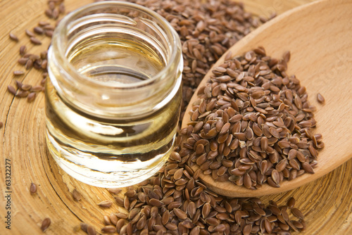 Photo: Linseed oil and flax seeds on wooden background Linseed oil and flax seeds on wooden background