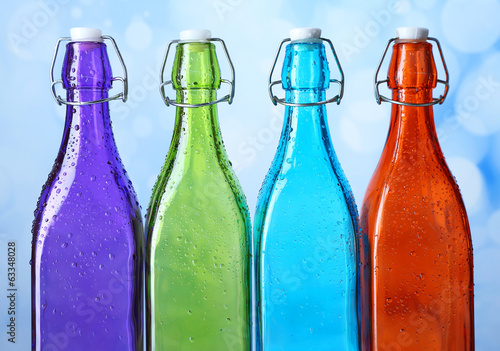 Photo: Colorful bottles on light background Colorful bottles on light background