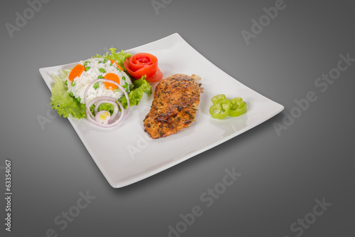Photo: Chicken fillet on plate isolated on gray background Chicken fillet on plate isolated on gray background