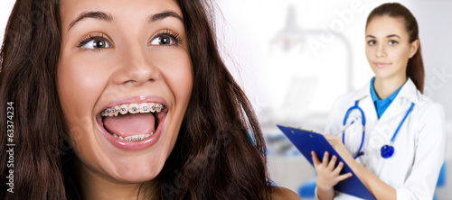 Photo: Happy beautiful girl with braces. Happy beautiful girl with braces.