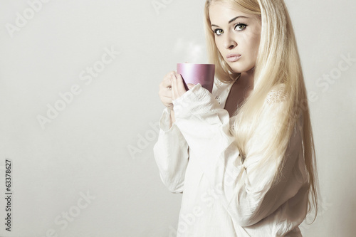 Photo: Beautiful blond woman with Coffee.Vapor Cup of tea. Hot drink Beautiful blond woman with Coffee.Vapor Cup of tea. Hot drink