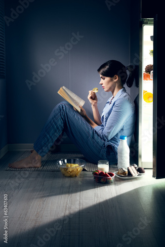 Photo: Sleepless woman reading in the kitchen Sleepless woman reading in the kitchen