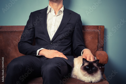 Photo: Young man and cat relaxing on sofa Young man and cat relaxing on sofa